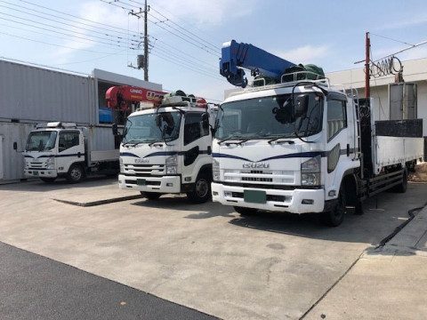 クレーン付きトラック（ユニック車）が並ぶ駐車場