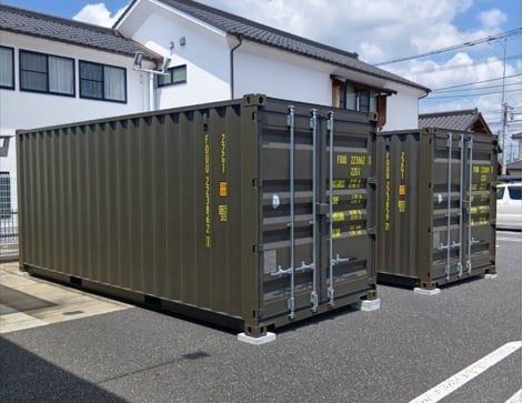 住宅前の駐車場にオリーブ色の20フィートコンテナ2台を並べた様子